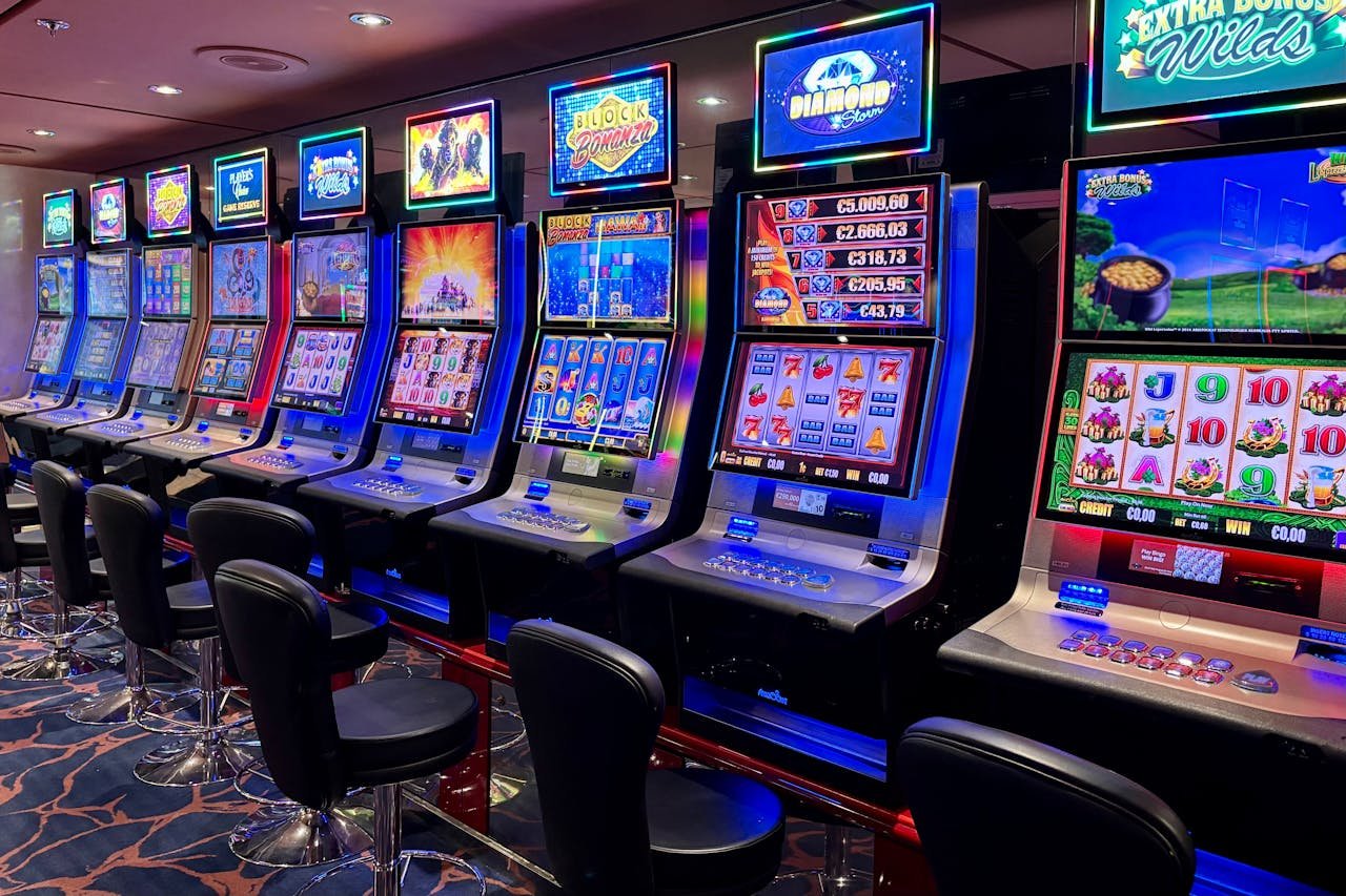Bright casino slot machines with colorful displays and no people present.