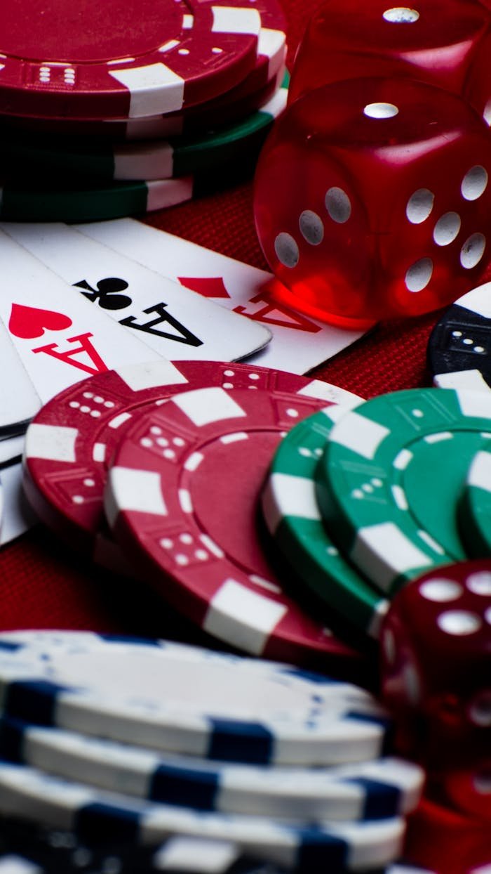 Colorful assortments of poker chips, dice, and playing cards create a vivid casino scene.
